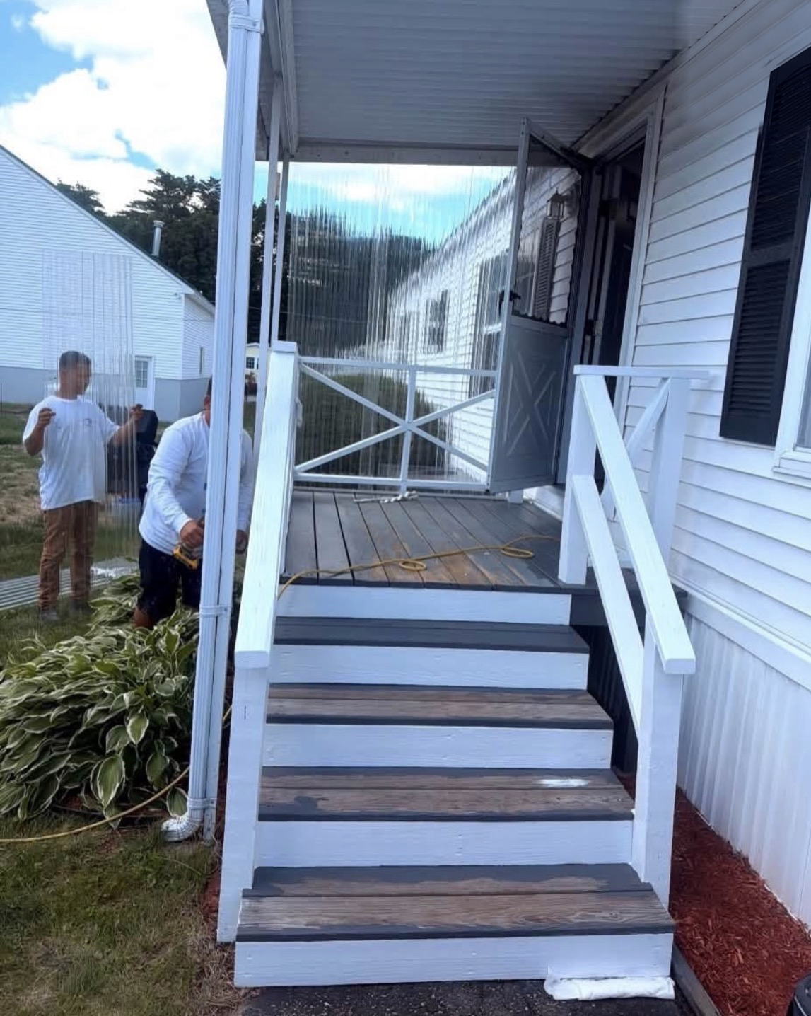 Front porch and entry stairs with worn, peeling paint and bare wood showing on the treads before painting