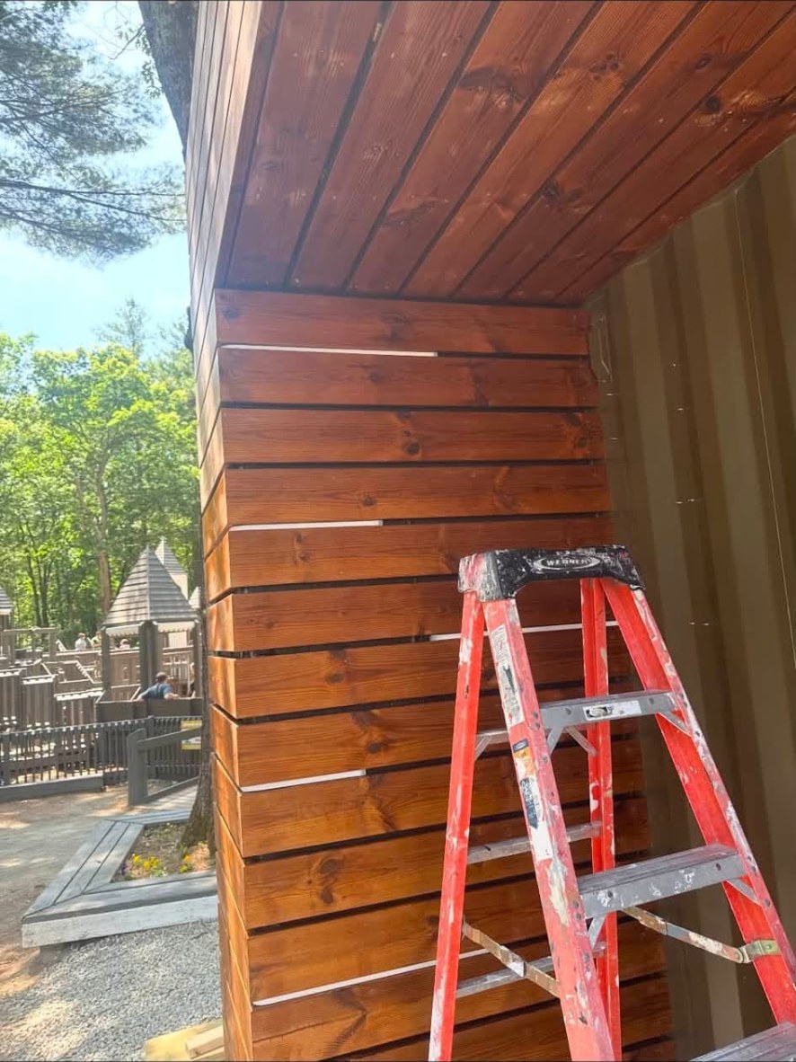 Cedar siding and ceiling boards freshly stained a rich warm brown