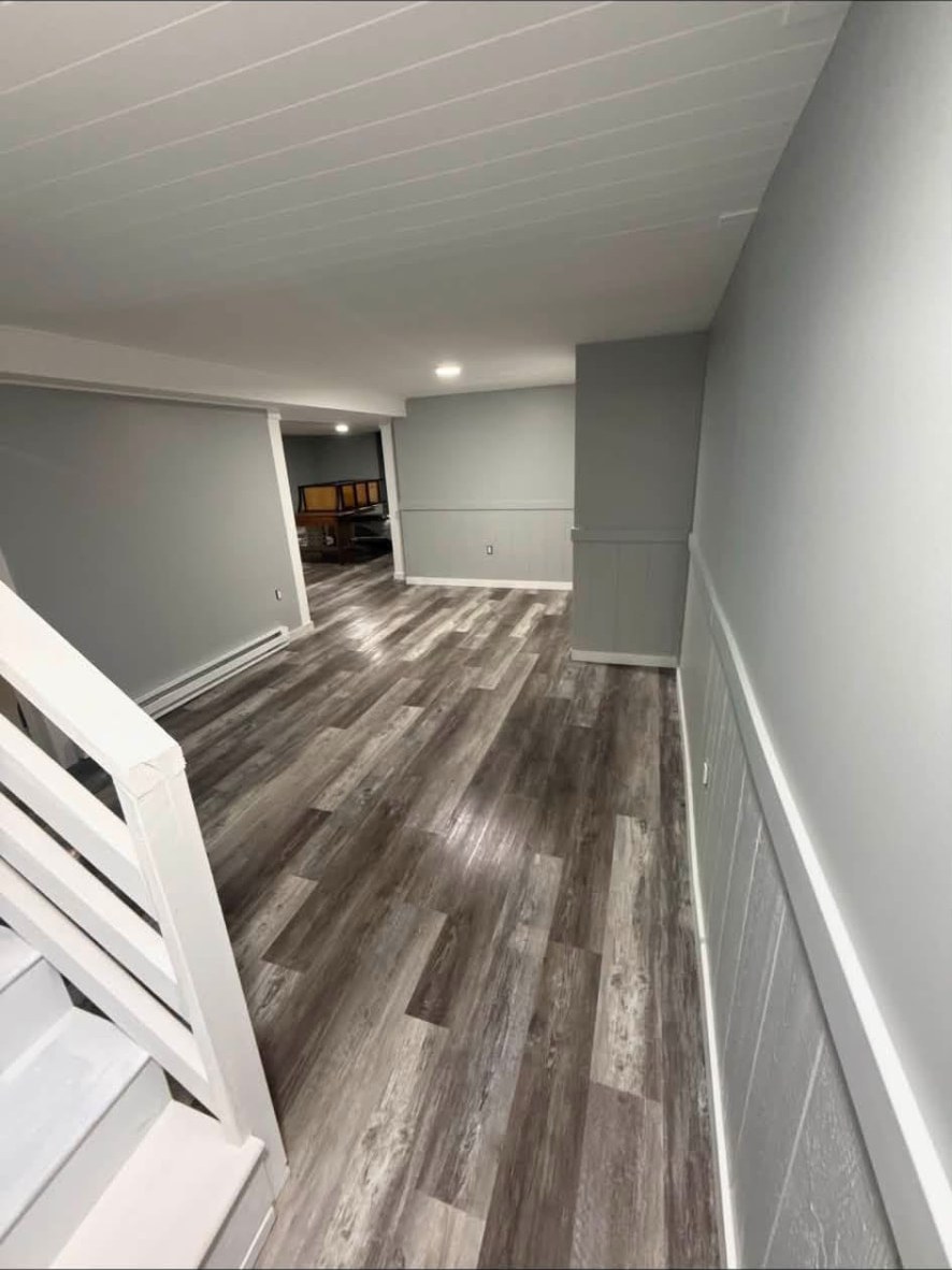 Finished basement with painted gray walls, white trim, and new flooring